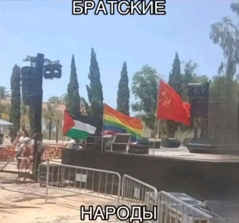 Photograph of the Palestinian, LGBT and a hammer and sickle flag next to each other. The caption is in Russian and means: fraternal peoples.