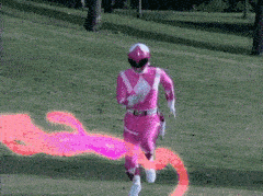 The pink power ranger running through explosions